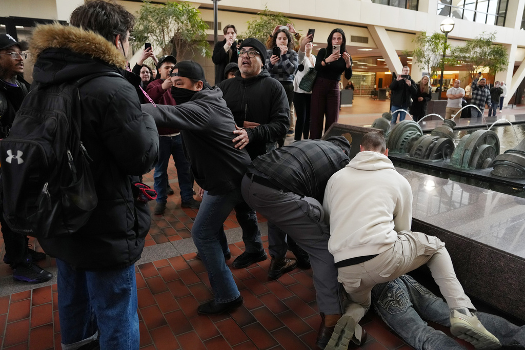 Plain clothed federal agents tackle and arrest a man after a short foot chase in the lobby of the Hennepin County Government Center in Minneapolis, on Tuesday, Feb. 10, 2026. (Anthony Souffle/Star Tribune via AP)