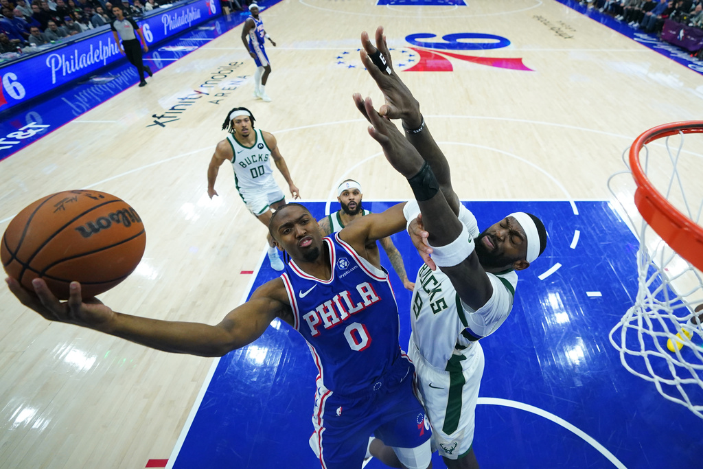 Philadelphia 76ers' Tyrese Maxey, left, goes up for a shot against Milwaukee Bucks' Bobby Portis during the first half of an NBA basketball game Tuesday, Jan. 27, 2026, in Philadelphia. (AP Photo/Matt Slocum)