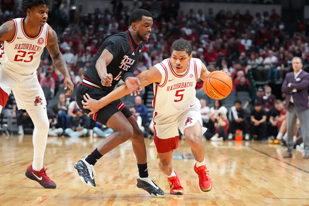 Arkansas guard Darius Acuff Jr. (5) drives against Texas Tech forward Donovan Atwell (12) as Arkansas forward Nick Pringle (23) looks on during the first half of an NCAA college basketball game Saturday, Dec. 13, 2025, in Dallas. (AP Photo/LM Otero)