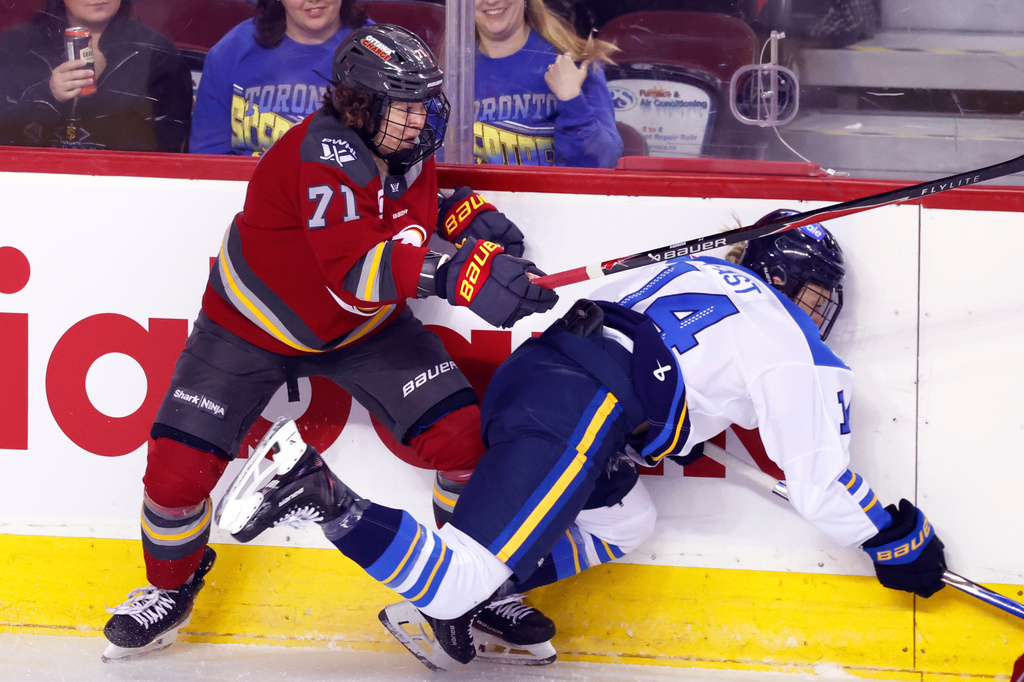 Toronto Sceptres' Renata Fast, right, is knocked down by Ottawa Charge's Fanuza Kadirova during first period PWHL Takeover Tour hockey game in Calgary, on Wednesday, April 1, 2026. (Larry MacDougal/The Canadian Press via AP)