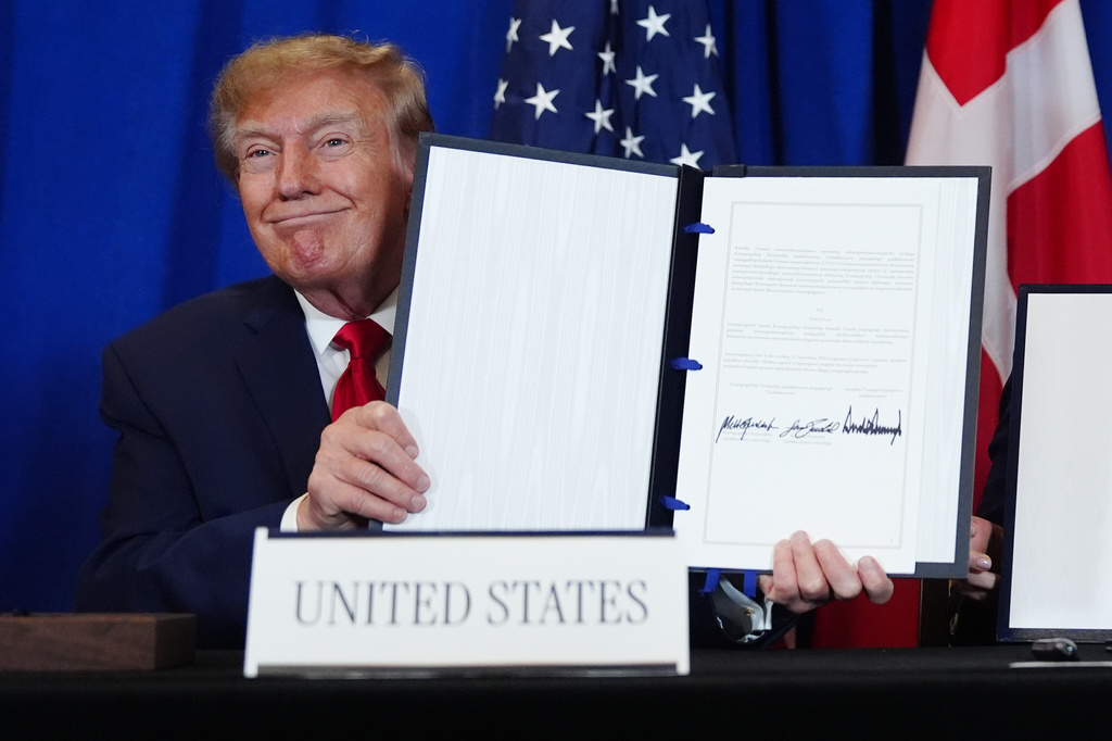 President Donald Trump holds up the document after signing a security agreement with Denmark's Prime Minister Mette Frederiksen and Greenland's Prime Minister Jens-Frederik Nielsen during the United Nations General Assembly, Tuesday, Sept. 22, 2026, at the UN headquarters. (AP Photo/Julia Demaree Nikhinson)