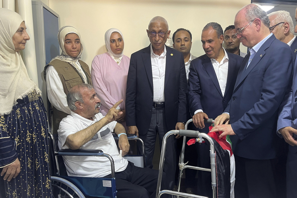 Palestinian Prime Minister Mohammed Mustafa, right, and Egyptian Foreign Minister Badr Abdelatty, second right, visit Palestinian Mohammed Abu Dakkah, from Gaza Strip, who receives medical care at Arish hospital, in Arish, Egypt, Monday, Aug. 18, 2025. (AP Photo/Mohamed Arafat)
