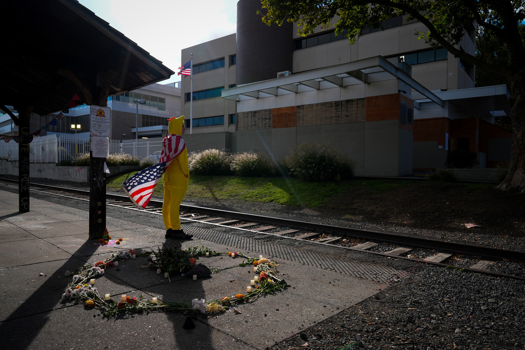 FILE - Jack Dickinson, dressed in a chicken costume, looks to other protesters outside a United States Immigration and Customs Enforcement (ICE) facility in Portland, Ore., Monday, Oct. 20, 2025. (AP Photo/Jenny Kane,File)