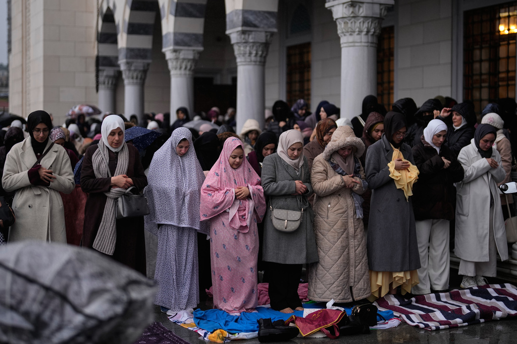 Muslim worshippers attend Eid al-Fitr prayers outside a mosque in Istanbul, Friday, March 20, 2026. (AP Photo/Khalil Hamra)