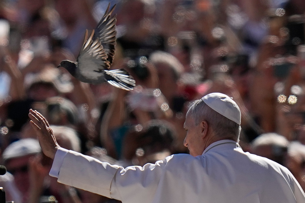 A pigeon flies past Pope Leo XIV as he arrives for his weekly general audience in St. Peter's Square, at the Vatican, Wednesday, Sept. 23, 2026. (AP Photo/Alessandra Tarantino)