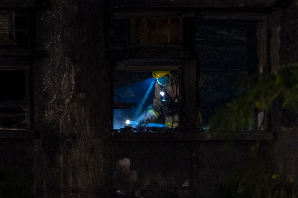 A firefighter searches through a building in the aftermath of a fire at Wang Fuk Court, a residential estate in the Tai Po district of Hong Kong's New Territories, Thursday, Nov. 27 2025. (AP Photo/Ng Han Guan)