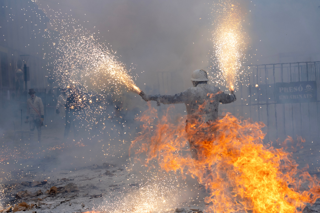 Revellers take part in the Els Enfarinats festival, a battle using flour, eggs and firecrackers, in the town of Ibi near Alicante, Spain, Sunday Dec. 28, 2025. (AP Photo/Alberto Saiz)