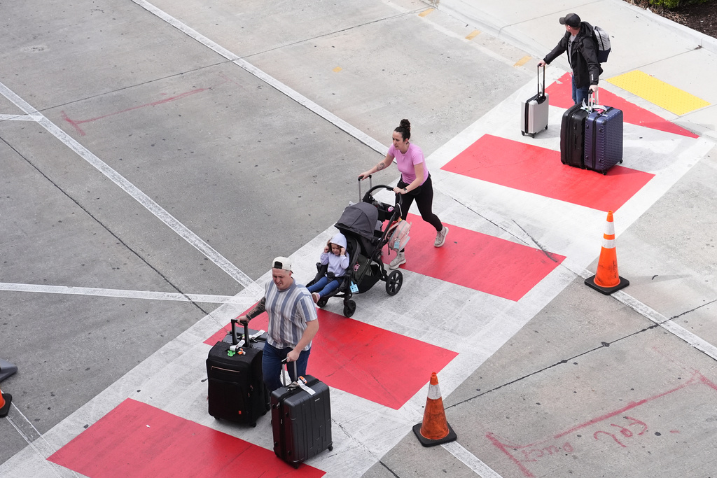 Travelers walk with their luggage from Fort Lauderdale-Hollywood International Airport, Thursday, Nov. 13, 2025, in Fort Lauderdale, Fla. (AP Photo/Lynne Sladky)