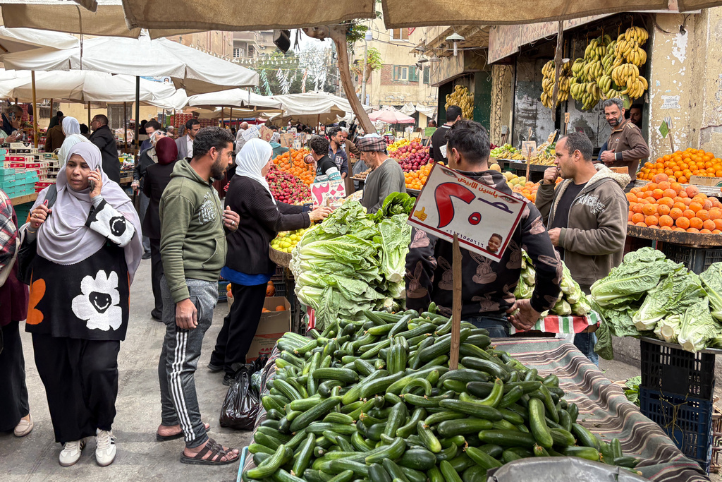 People buy vegetables at a popular market in Cairo, Egypt, Tuesday, March 12, 2026. (AP Photo/Amr Nabil)