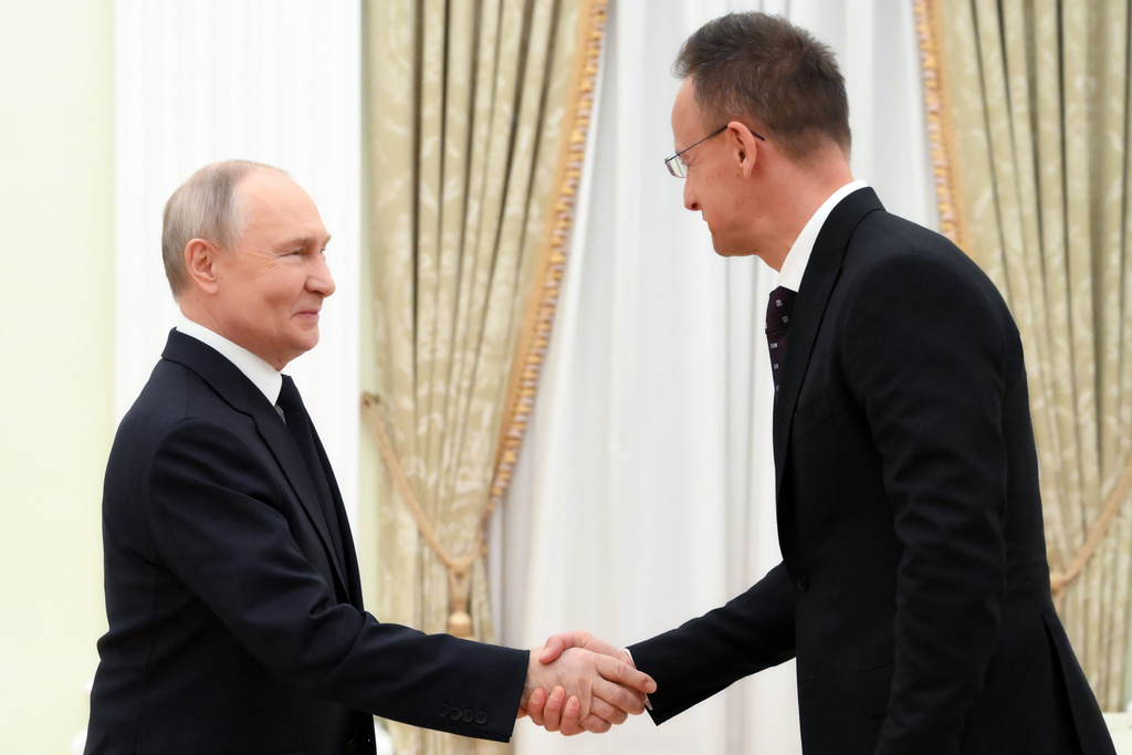 Russian President Vladimir Putin, left, and Hungarian Foreign Minister Peter Szijjarto shake hands during their meeting at the Senate Palace of the Kremlin in Moscow, Wednesday, March 4, 2026. (Grigory Sysoyev, Sputnik, Kremlin Pool Photo via AP)