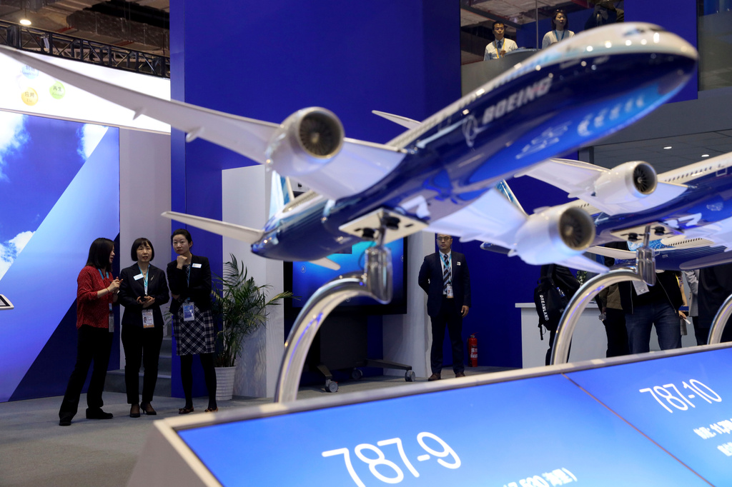 FILE - Visitors chat near models of Boeing passenger jets displayed at the China International Import Expo in Shanghai on Wednesday, Nov. 6, 2019. (AP Photo/Ng Han Guan, File)