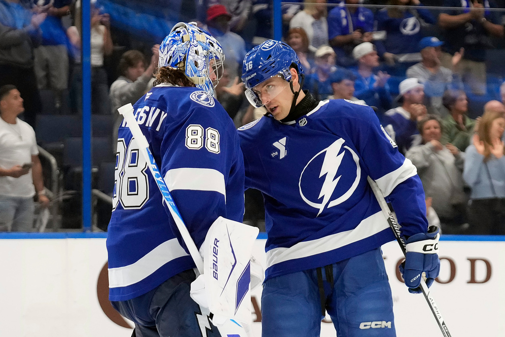 Tampa Bay Lightning goaltender Andrei Vasilevskiy (88) celebrates with defenseman Steven Santini after the team defeated the Calgary Flames during an NHL hockey game Wednesday, Nov. 26, 2025, in Tampa, Fla. (AP Photo/Chris O'Meara)
