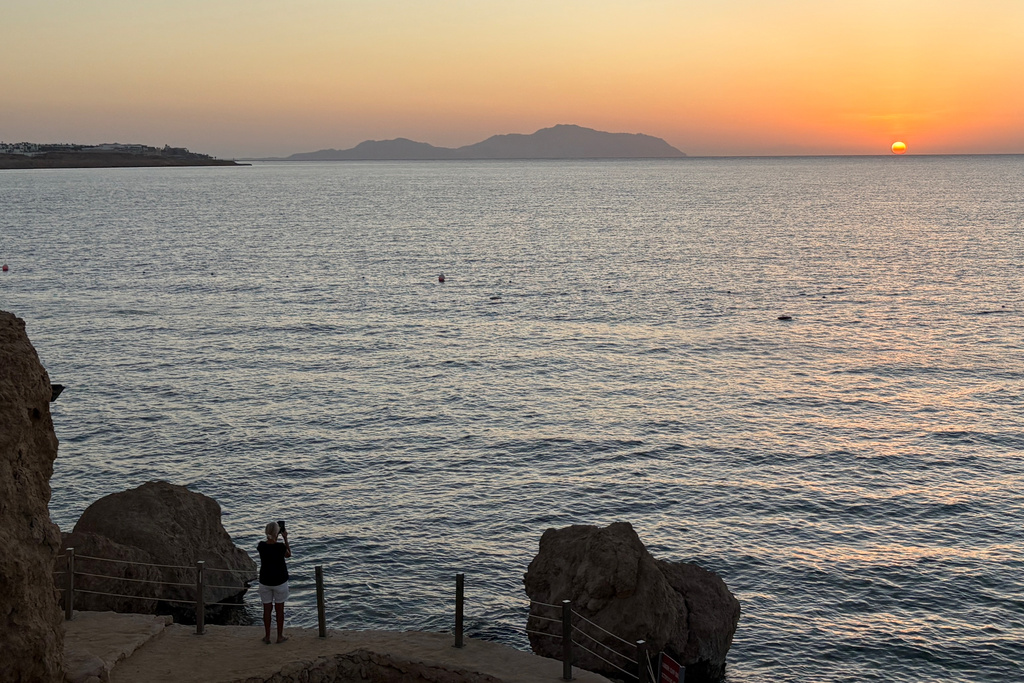 A tourist films the sunrise at the Red Sea city of Sharm el-Sheikh, Egypt, where Israeli and Hamas officials are set to hold indirect talks, on Tuesday, Oct. 7, 2025. (AP Photo)