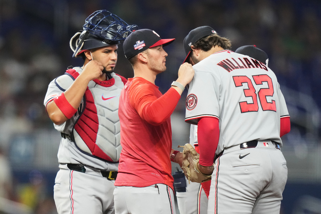 Washington Nationals manager Blake Butera, left, talks with relief pitcher Trevor Williams (32) during the fifth inning of a baseball game against the Miami Marlins, Sunday, Aug. 23, 2026, in Miami. (AP Photo/Lynne Sladky)