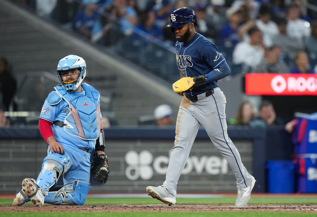 Tampa Bay Rays' Cedric Mullins (31) scores a run after a walk while the bases were loaded as Toronto Blue Jays catcher Alejandro Kirk (30) looks on during sixth inning of a baseball game in Toronto on Wednesday, July 22, 2026. (Nathan Denette/The Canadian Press via AP)