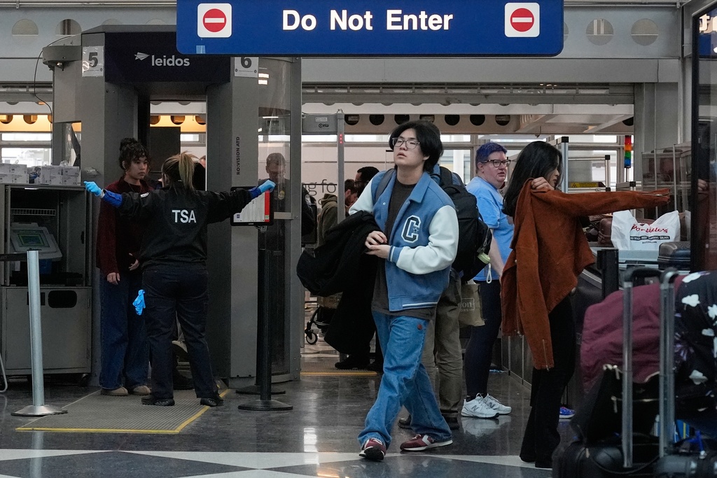 Travelers go through TSA security check at O'Hare International Airport, Saturday, March 21, 2026, in Chicago. (AP Photo/Kiichiro Sat0)