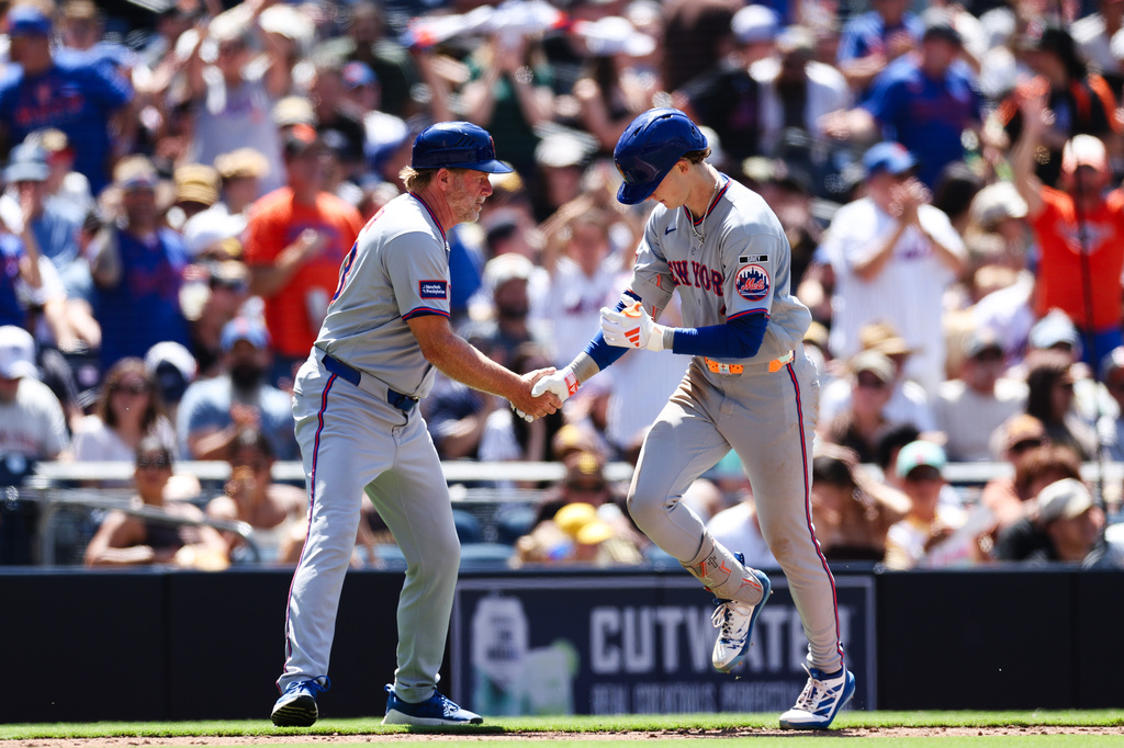 New York Mets' Carson Benge, right, is congratulated by third base coach Tim Leiper, left, as he rounds third after hitting a solo home run against the San Diego Padres in the sixth inning of a baseball game Sunday, June 7, 2026, in San Diego. (AP Photo/Derrick Tuskan)