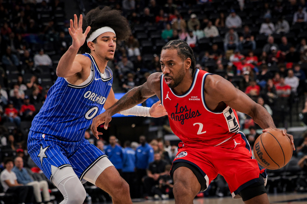 Los Angeles Clippers forward Kawhi Leonard, right, dribbles past Orlando Magic guard Anthony Black during the second half of a NBA basketball game, Sunday, Feb. 22, 2026, in Inglewood, Calif. (AP Photo/Etienne Laurent)