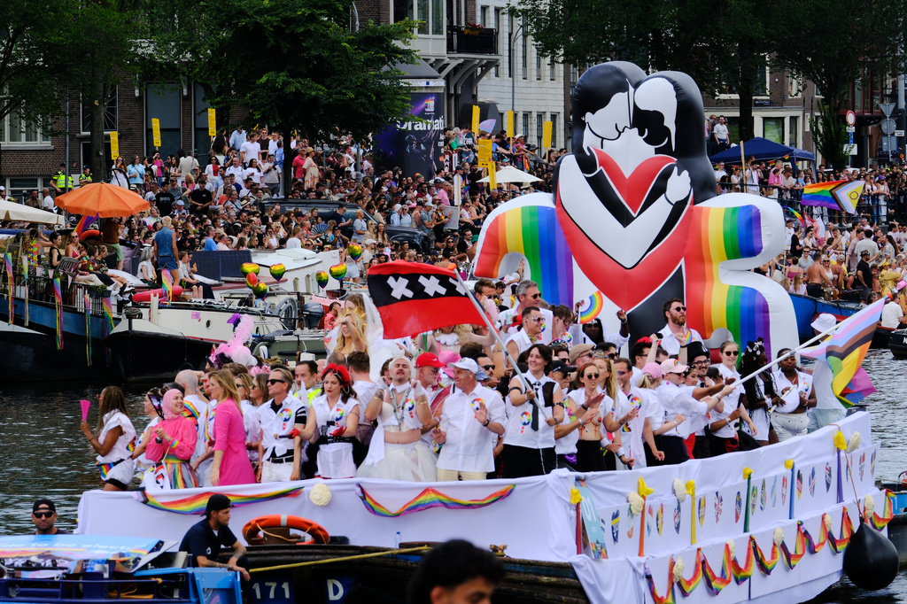People line the Dutch capital's historic canals Saturday, Aug. 1, 2026, to watch the Canal Parade, the most popular event of the Pride Amsterdam festival that attracts tens of thousands of visitors to the city. (AP Photo/Patrick Post)