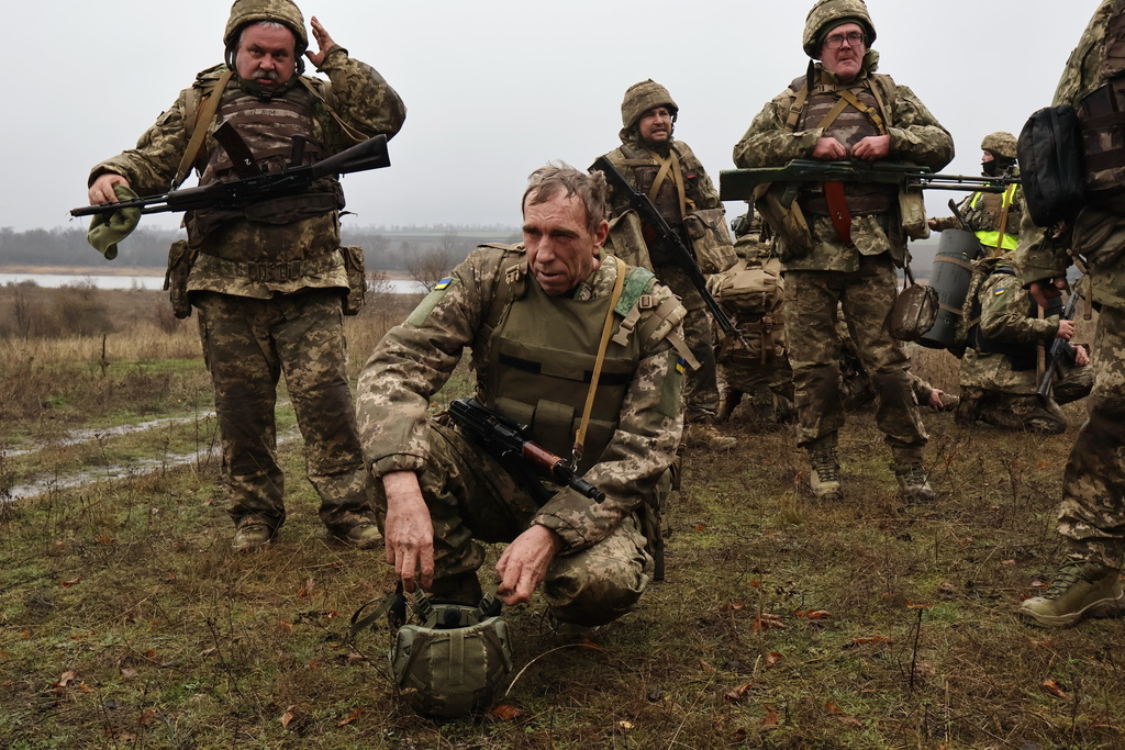 In this photo provided by Ukraine's 65th Mechanized Brigade press service, recruits rest after drills at a training ground in the Zaporizhzhia region, Ukraine, Friday, Dec. 12, 2025. (Andriy Andriyenko/Ukraine's 65th Mechanized Brigade via AP)