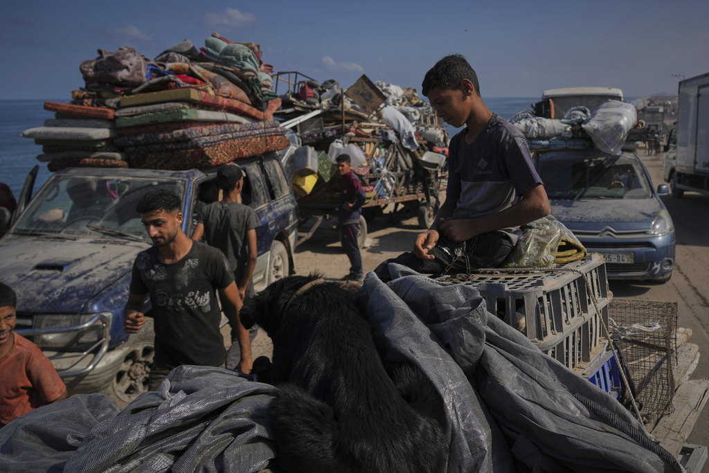 Displaced Palestinians carry their belongings as they flee northern Gaza along the coastal road toward the south, as Israel announced an expanded operation in Gaza City, Tuesday, Sept. 16, 2025. (AP Photo/Abdel Kareem Hana)