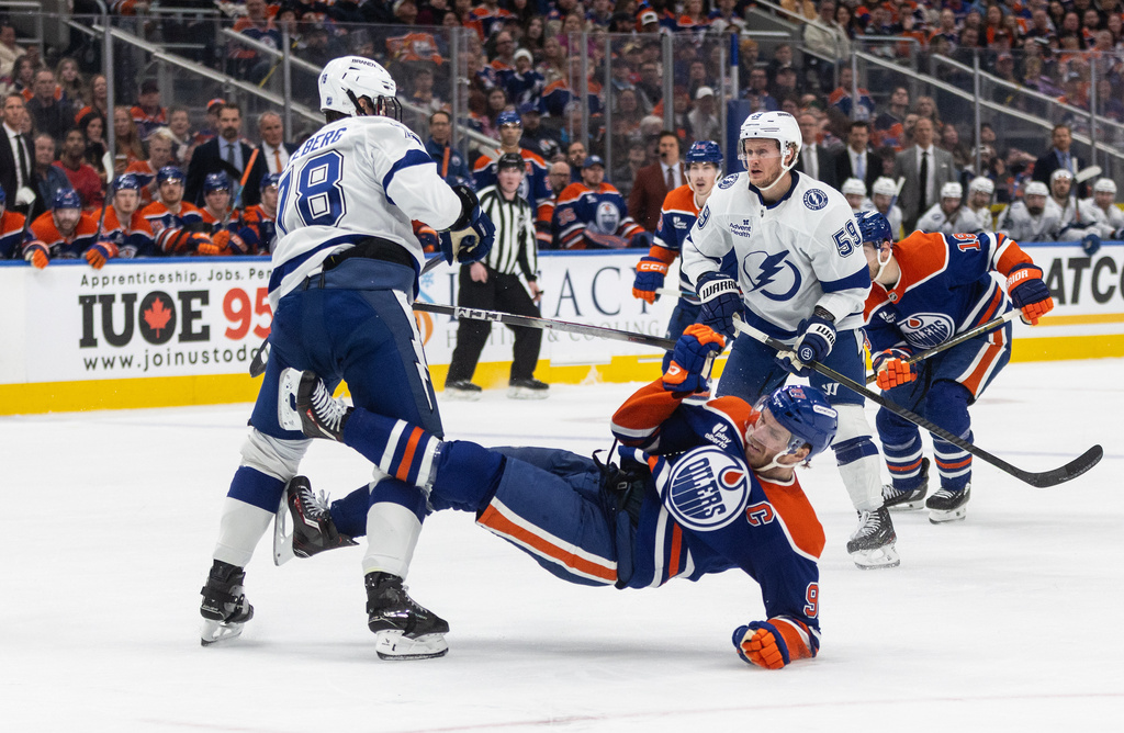 Tampa Bay Lightning's Emil Lilleberg (78) checks Edmonton Oilers' Connor McDavid (97) during second period NHL action, in Edmonton on Saturday March 21, 2026. (Jason Franson/The Canadian Press via AP)