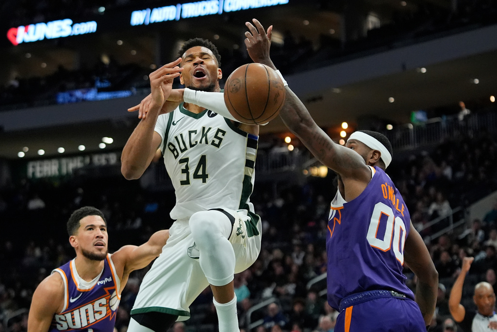 Milwaukee Bucks' Giannis Antetokounmpo (34) loses control of the ball after being fouled on a drive against Phoenix Suns' Royce O'Neale and Devin Booker during the first half of an NBA basketball game Tuesday, March 10, 2026, in Milwaukee. (AP Photo/Aaron Gash)