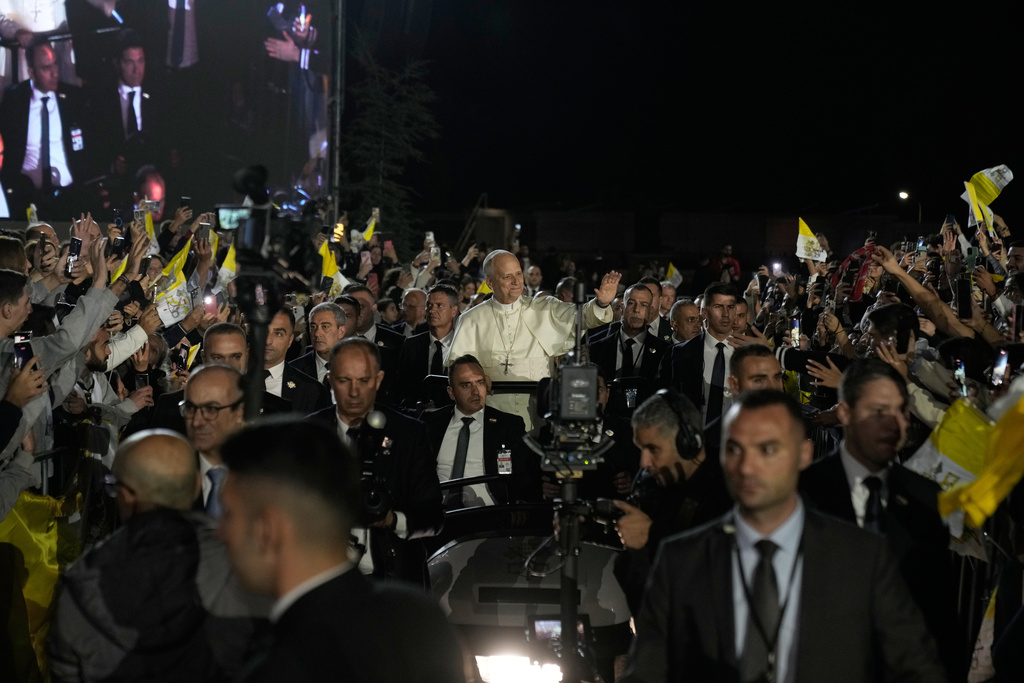 Pope Leo XIV greets the crowd as he arrives surrounded by security for a meeting with youths in Bkerki, the seat of the Maronite Church, in Lebanon, Monday, Dec. 1, 2025. (AP Photo/Bilal Hussein)