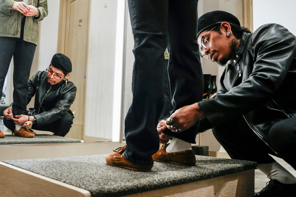 Tailor Marco Lema, 35, of Ecuador, measures a denim alteration at Nordstrom headquarters in New York, Monday, March 23, 2026. (AP Photo/Eduardo Munoz Alvarez)