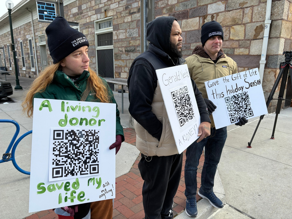 Riley Brubaker, left, Gerald Cameron and David Krissman, right, spread the word about the need for kidney donors on Saturday, Dec. 13, 2025, outside Broad Street Market in Harrisburg, Pa. (AP Photo/Mark Scolforo)