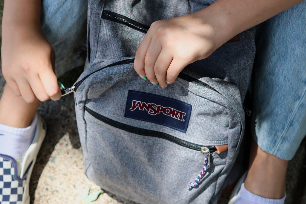 Middle school student Claire Knoth, 13, zips up her backpack after packing it with school supplies Friday, July 31, 2026, in Flagstaff, Ariz. (AP Photo/Cheyanne Mumphrey)