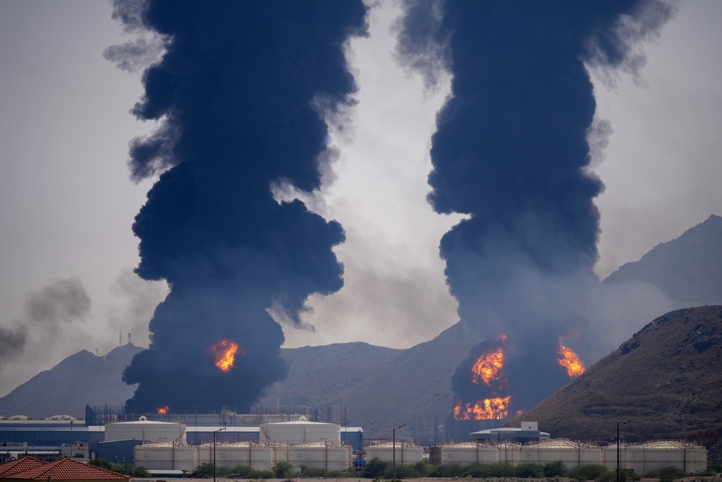FILE - Plumes of smoke and fire rise after debris from an intercepted Iranian drone struck an oil facility, according to authorities, in Fujairah, United Arab Emirates, March 14, 2026. (AP Photo/Altaf Qadri, File)