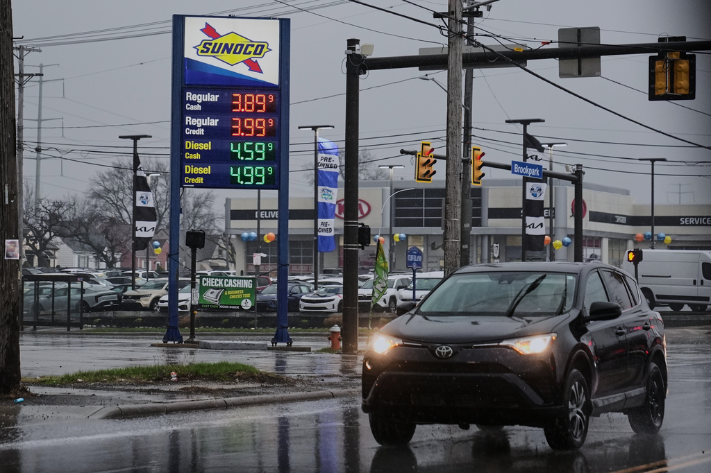 A car drives by a gas station with fuel prices displayed in Parma, Ohio, Thursday, March 26, 2026. (AP Photo/Sue Ogrocki)