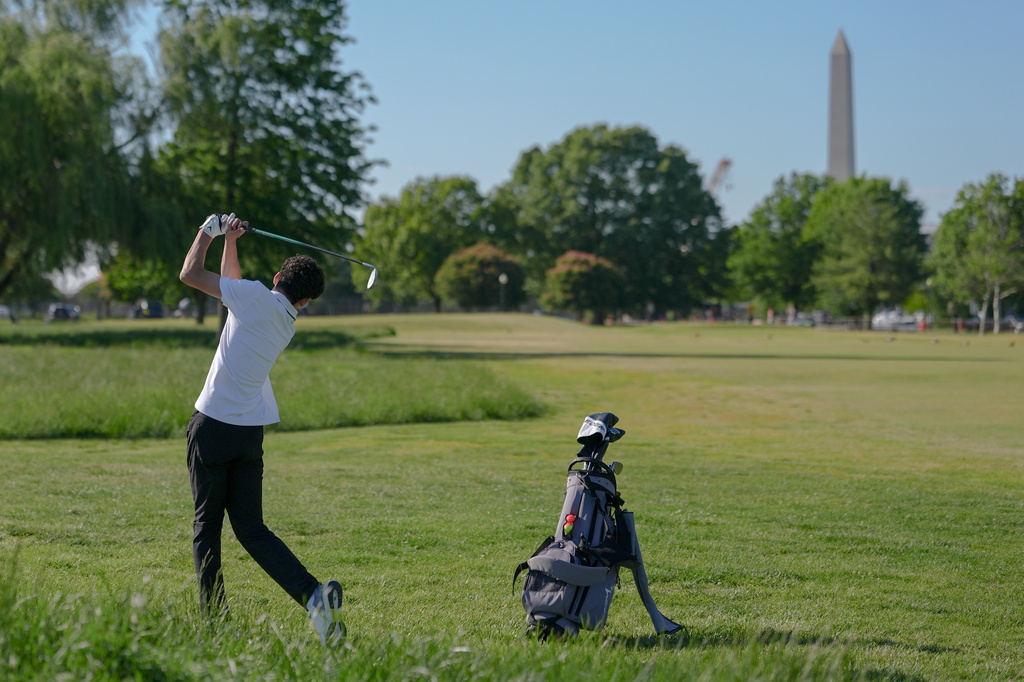 The Washington Monument stands in the background as Roman Sandoli swings at the East Potomac Golf Course, Sunday, May 3, 2026, in Washington. (AP Photo/Julia Demaree Nikhinson)