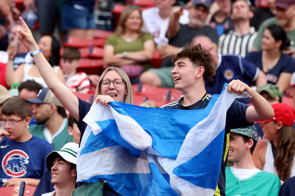 Fans of the Scotland men's soccer team sing and dance before a baseball game between the Boston Red Sox and the Texas Rangers, Sunday, June 14, 2026, in Boston. (AP Photo/Mark Stockwell)