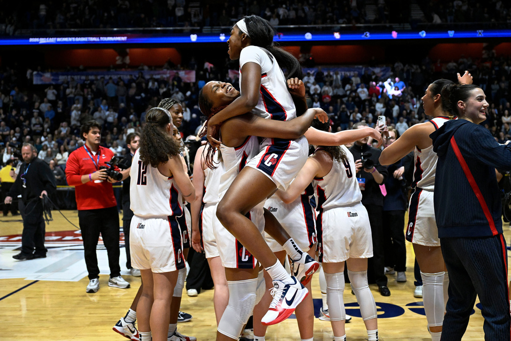 UConn forward Serah Williams, right, jumps into the arms of UConn guard Blanca Quinonez, left, as they celebrate winning an NCAA college basketball game against Villanova in the finals of the Big East tournament, Monday, March 9, 2026, in Uncasville, Conn. (AP Photo/Jessica Hill)