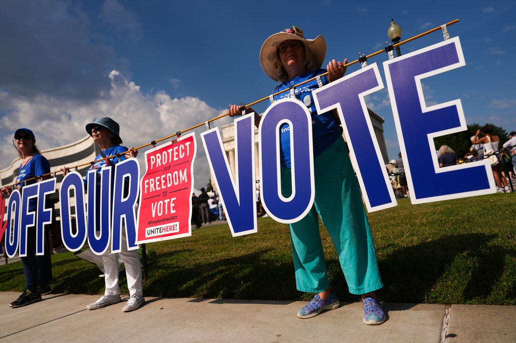 Demonstrators holds a sign during the March on Washington, Friday, Aug. 28, 2026, near the Lincoln Memorial in Washington. (AP Photo/Julia Demaree Nikhinson)