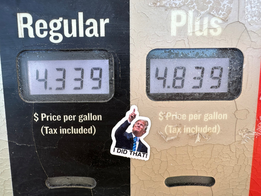 A sticker of President Donald J. Trump points to the electronically-posted prices for a gallon of regular or regular plus gasoline available at a Conoco station Saturday, May 30, 2026, in Denver. (AP Photo/David Zalubowski)