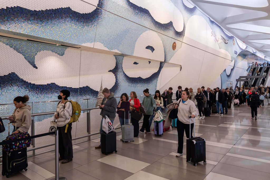 People wait in line at a Transportation Security Administration (TSA) security checkpoint at LaGuardia Airport (LGA) in the Queens borough of New York, Sunday, Nov. 9, 2025. (AP Photo/Adam Gray)