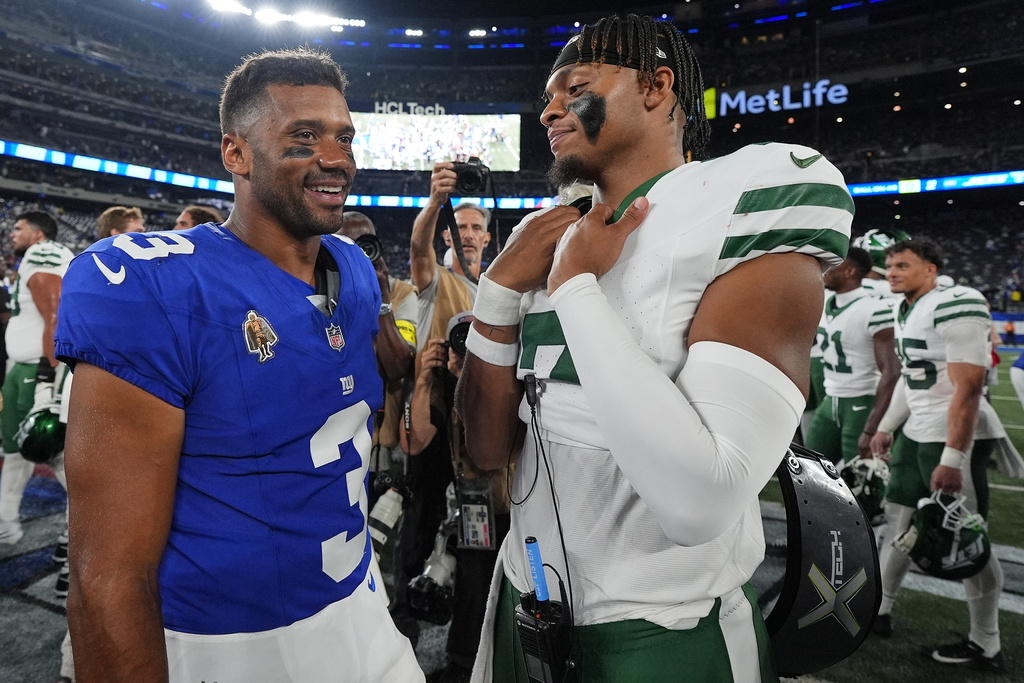 New York Giants quarterback Russell Wilson (3) and New York Jets quarterback Justin Fields (7) meet on the field after playing in an NFL football game, Saturday, Aug. 16, 2025, in East Rutherford, N.J. (AP Photo/Yuki Iwamura)