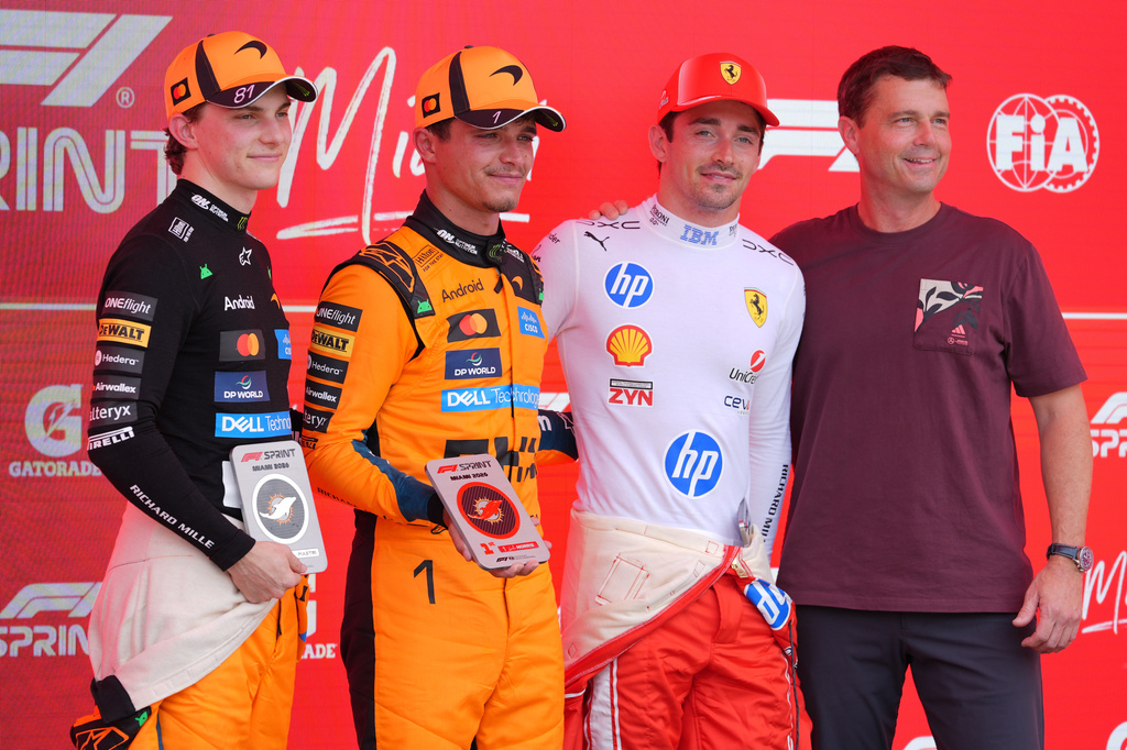 Astronaut Reid Wiseman, right, poses for a photo with (from left) third place finisher McLaren driver Oscar Piastri of Australia, first place finisher McLaren driver Lando Norris of Britain, and third place finisher Ferrari driver Charles Leclerc of Monaco after a sprint auto race at the Miami Formula One Grand Prix, Saturday, May 2, 2026, in Miami Gardens, Fla. (AP Photo/Rebecca Blackwell)