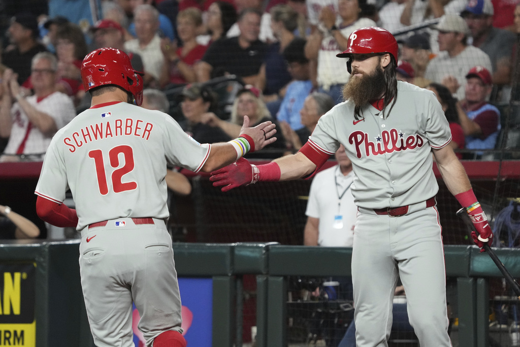Philadelphia Phillies' Kyle Schwarber celebrates with Brandon Marsh after scoring a run against the Arizona Diamondbacks on a ball hit by J.T. Realmuto in the first inning of a baseball game, Saturday, Sept. 20, 2025, in Phoenix. (AP Photo/Rick Scuteri)