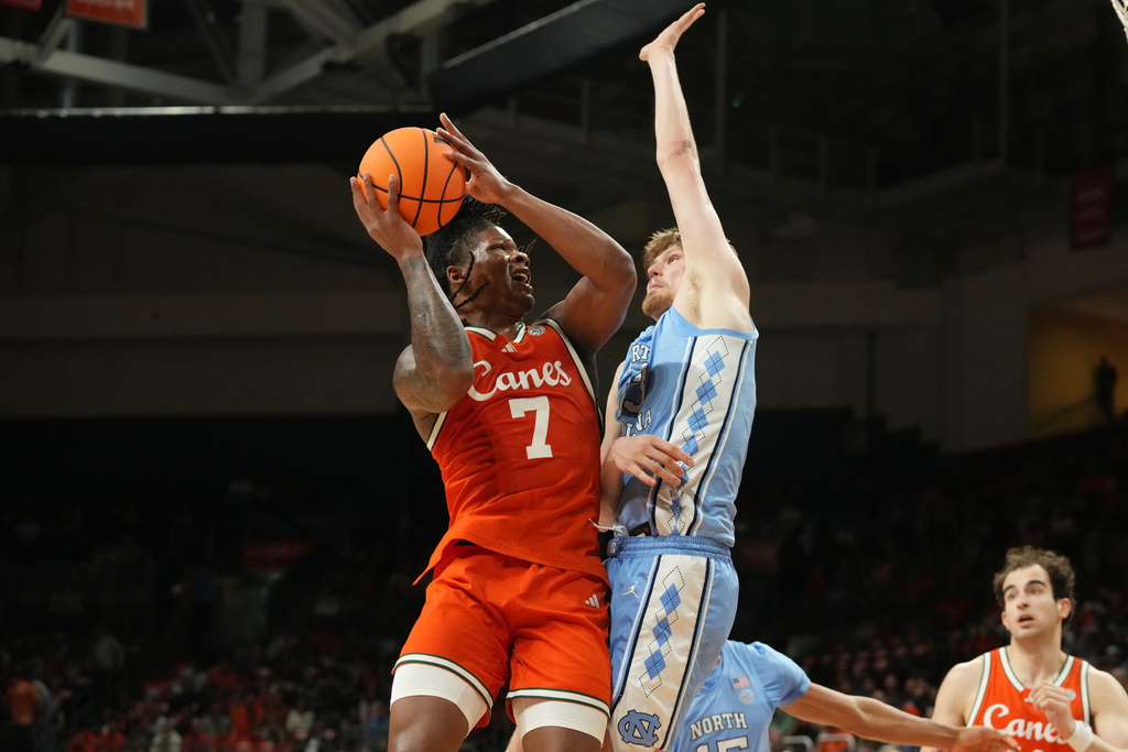 Miami forward Shelton Henderson (7) drives to the basket as North Carolina center Henri Veesaar (13) defends during the first half of an NCAA college basketball game, Tuesday, Feb. 10, 2026, in Coral Gables, Fla. (AP Photo/Marta Lavandier)