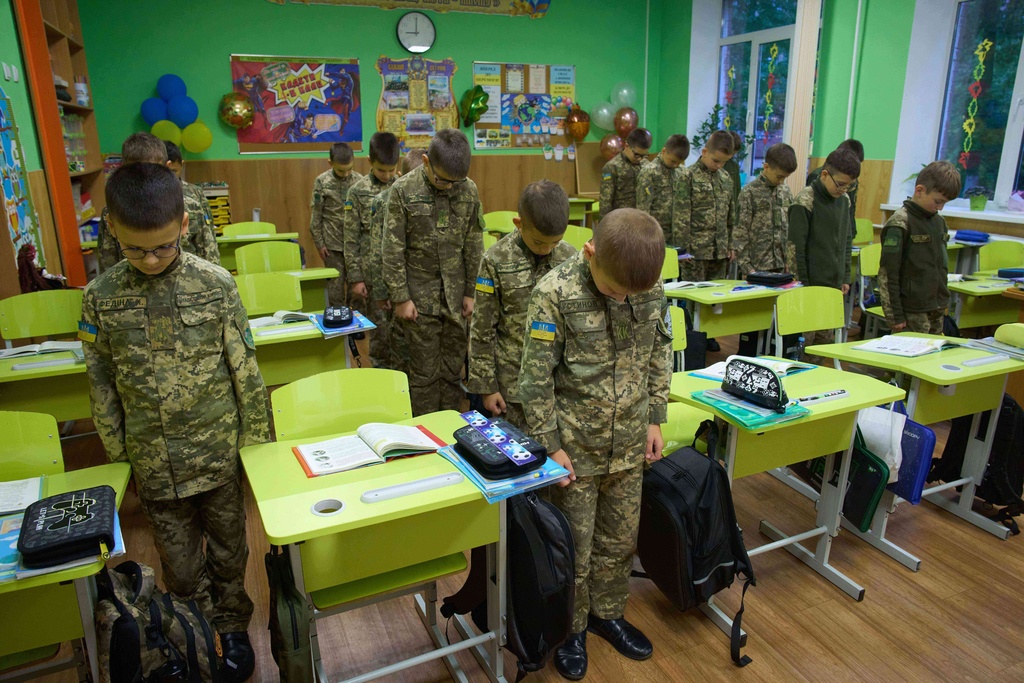 Cadets observe a nationwide minute of silence in memory of fallen soldiers, who defended their homeland in the war with Russia, in their classes at a cadets lyceum in Kyiv, Ukraine, Wednesday, Oct. 8, 2025. (AP Photo/Efrem Lukatsky)