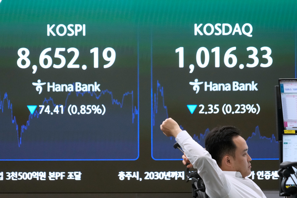 A currency trader stretches near a screen showing the Korea Composite Stock Price Index (KOSPI) at the foreign exchange dealing room of the Hana Bank headquarters in Seoul, South Korea, Wednesday, June 17, 2026. (AP Photo/Ahn Young-joon)