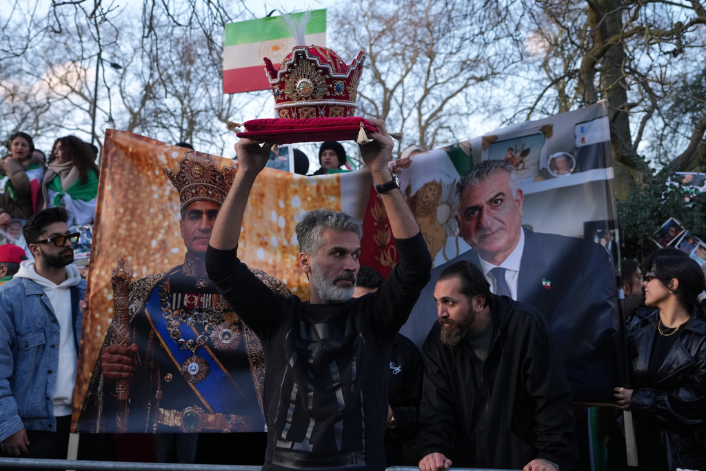 A protester holds a crown in London, Saturday, Feb. 28, 2026 after U.S. and Israeli forces carried out a series of strikes on Iran on Saturday morning. (AP Photo/Alastair Grant)