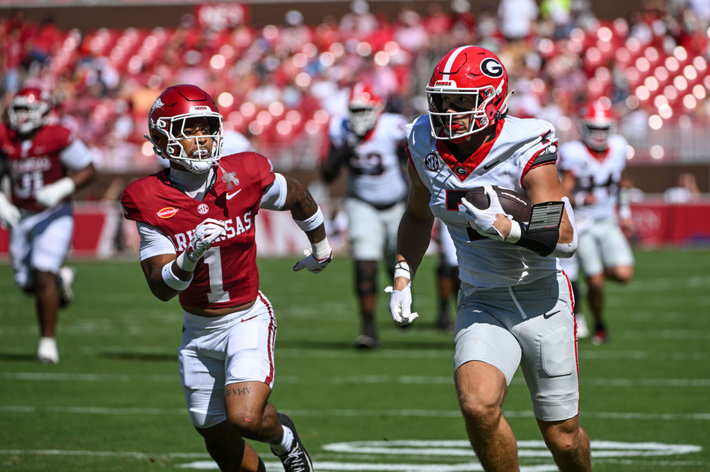 Georgia tight end Lawson Luckie (7) tries to get past Arkansas defensive back Christian Harrison (1) after a big catch during the first half of an NCAA college football game in Fayetteville, Ark., Saturday, Sept. 19, 2026. (AP Photo/Michael Woods)