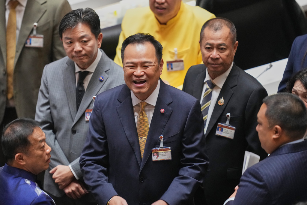 Thailand's Prime Minister Anutin Charnvirakul, center, smiles with lawmakers before he presents the policy statement at the Parliament in Bangkok, Thailand, Monday, Sept. 29, 2025. (AP Photo/Sakchai Lalit)