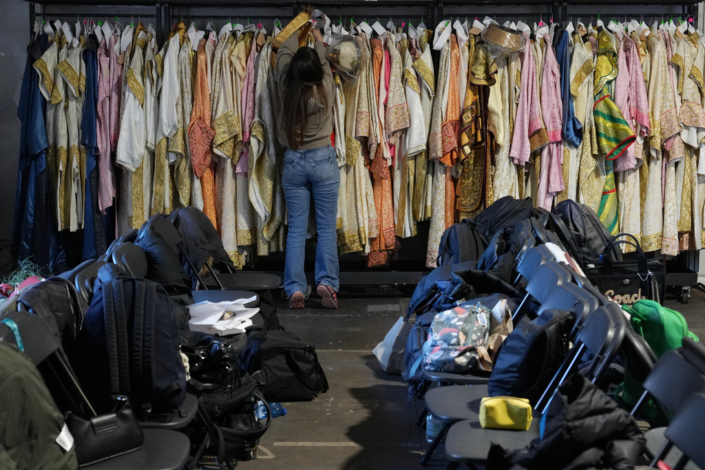 Dressmaker Luciana Donadio works in a dressing room outside the Arena ahead of the closing ceremony at the 2026 Winter Olympics, in Verona, Italy, Tuesday, Feb. 17, 2026. (AP Photo/Antonio Calanni)