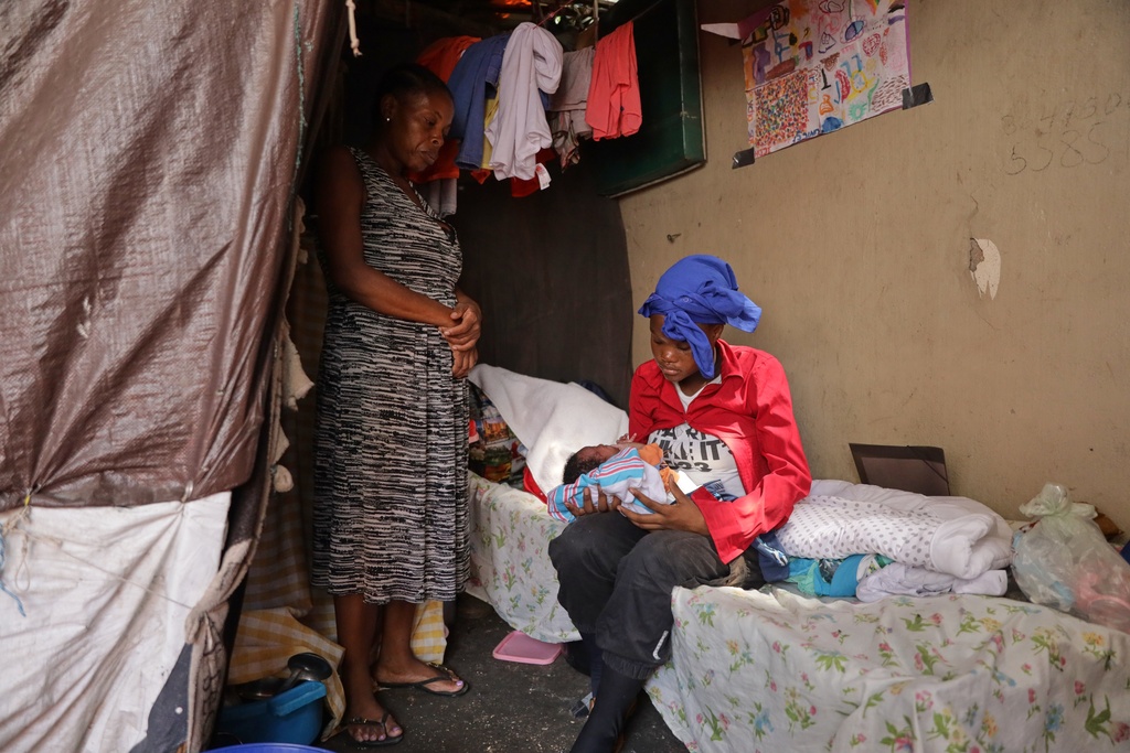 Desire Allia, 15, holds her 5-day-old baby while staying with her mother at a shelter for families displaced by gang violence in Port-au-Prince, Haiti, Tuesday, Oct. 7, 2025. (AP Photo/Patrice Noel)